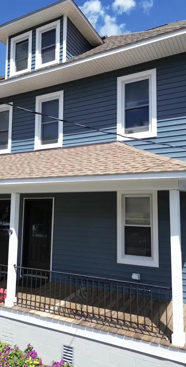 Front elevation of New Rochelle home in CertainTeed MainStreet Pacific Blue siding with white trim and new roof