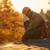 a detailed view of a well-maintained rooftop showcasing an inspection professional examining the roof’s surface while surrounded by clean gutters and properly managed overhanging trees, emphasizing the importance of proactive roof management.