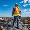 a professional contractor inspects a damaged roof under a clear blue sky, surrounded by a cityscape, emphasizing the contrast between the storm's aftermath and the insurance coverage discussion.