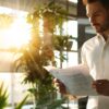 a sleek, modern office with a confident homeowner reviewing a detailed checklist on a tablet, surrounded by professional roofing documents, emphasizing the importance of verifying a roofer's credentials.